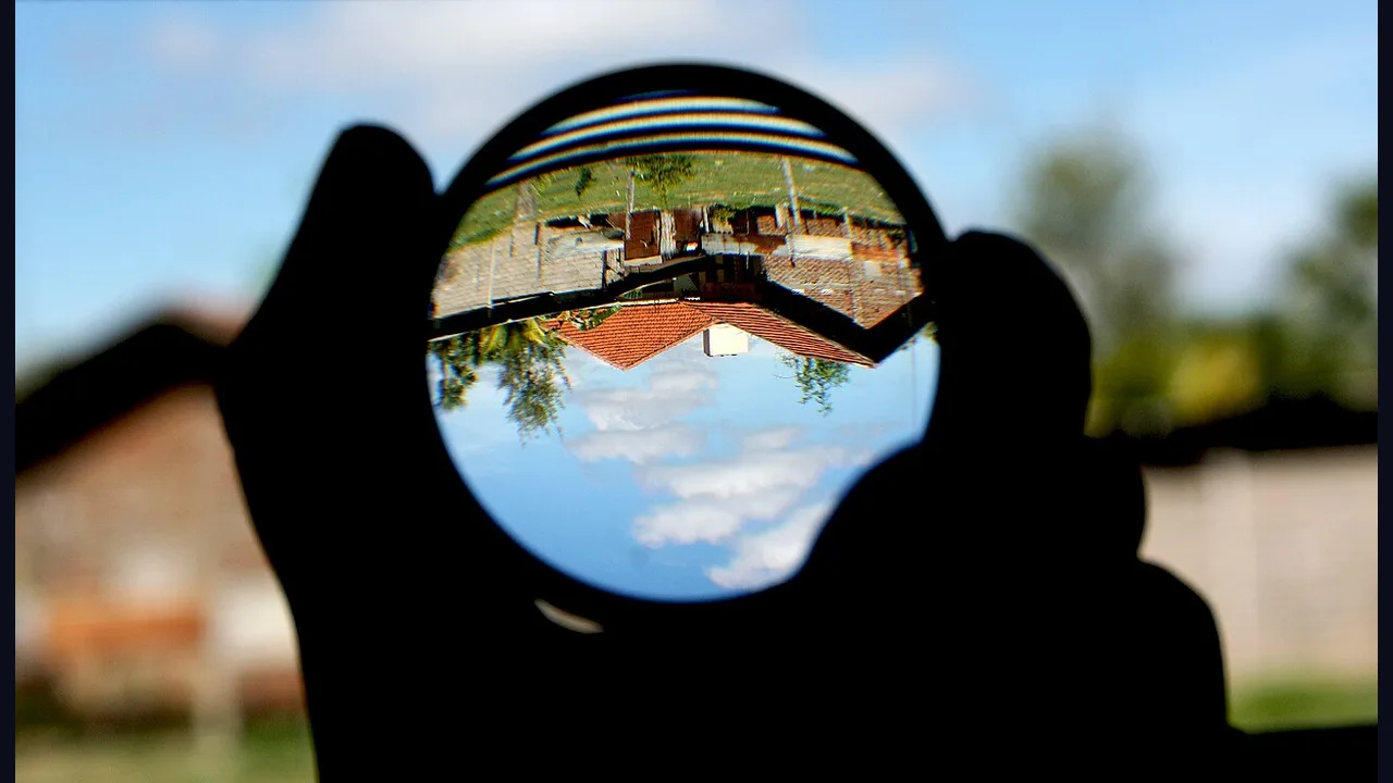A hand holding a magnifying lens